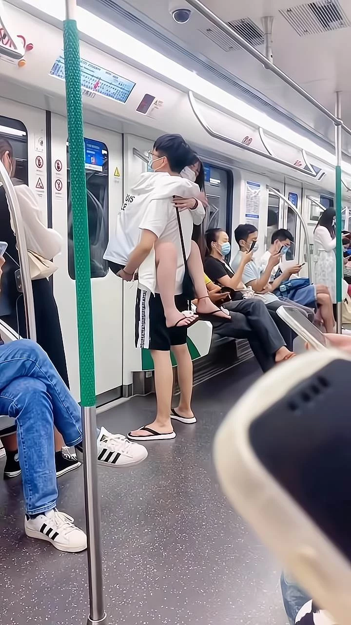 女子在捷運上犯困，沒有座位站著睡覺，男友熊抱姿勢引網友熱議：愛一個人把他當作孩子一樣寵