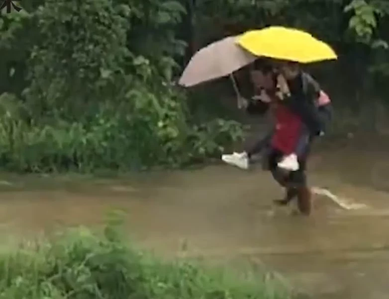 女兒回娘家吃飯，突遇暴雨積水，爸爸穿圍裙撐傘去接，背著女兒蹚水，就像小時候那樣，網友：在父親眼裡，女兒永遠都是小公主